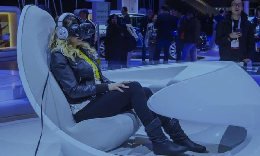 a woman using VR goggles while playing games at trade show booth